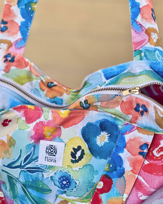 Floral-patterned bag with a visible brand logo on a matching background