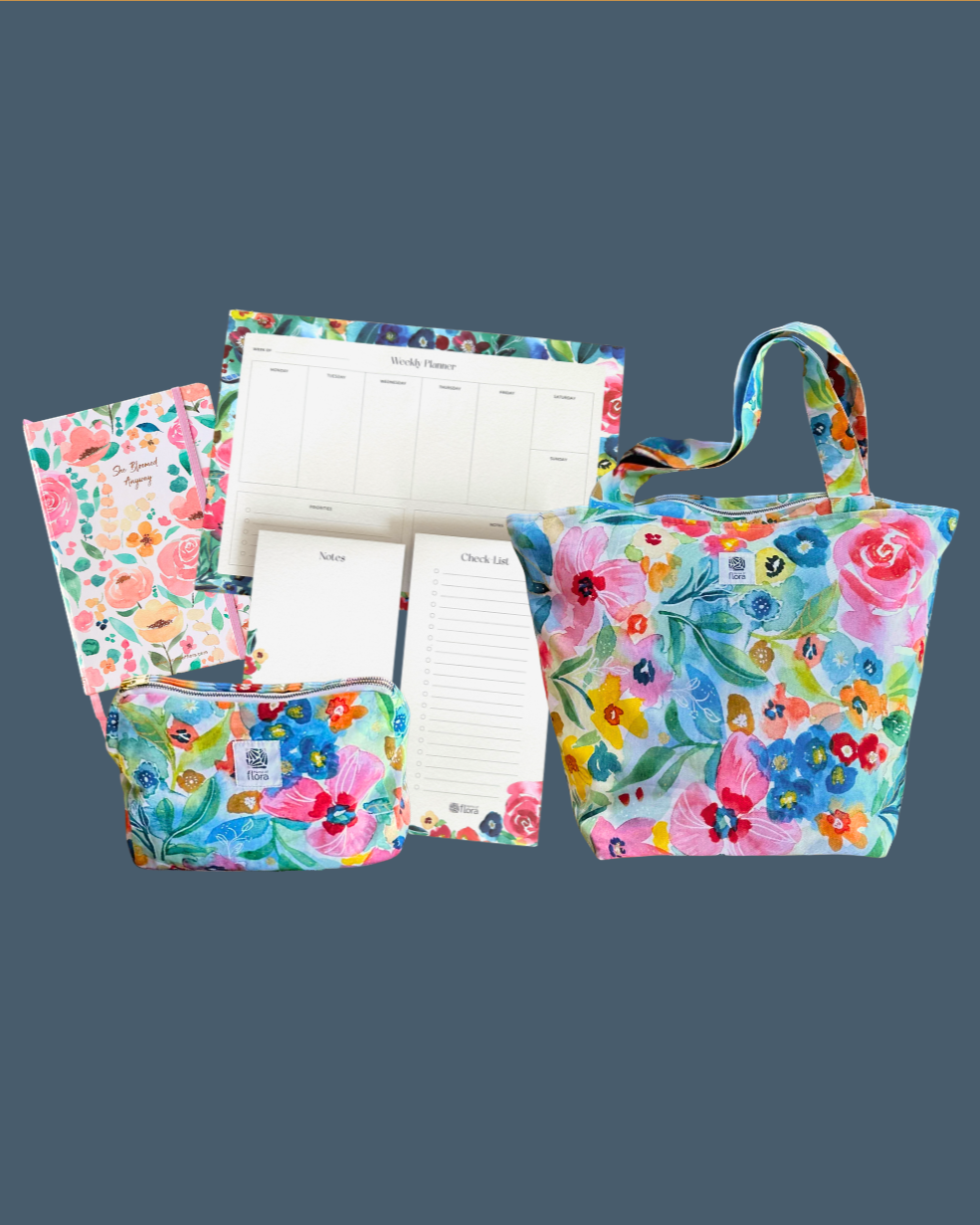 Set of floral-patterned bags and planners on a gray background
