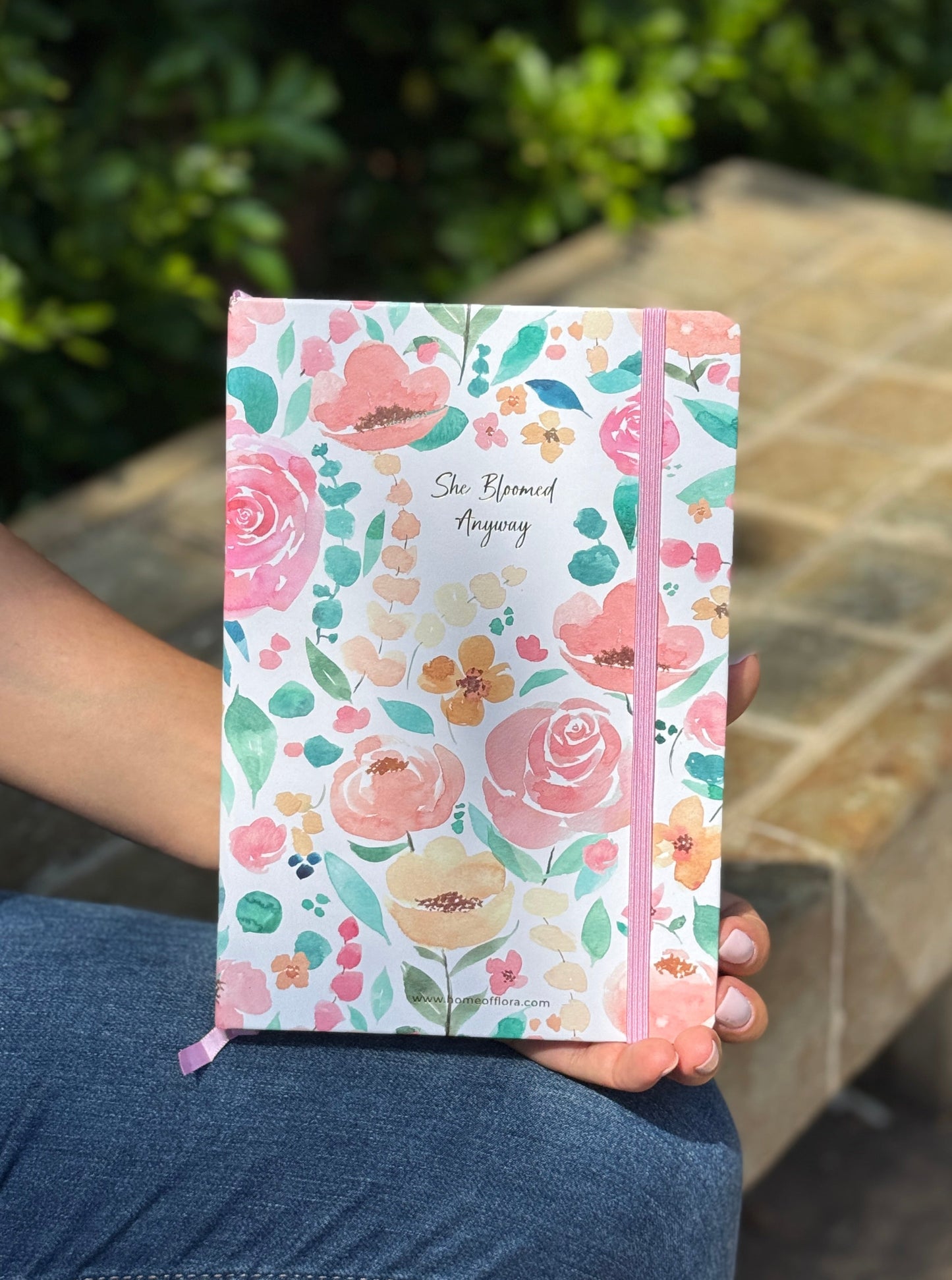 Floral notebook held by a person sitting outdoors