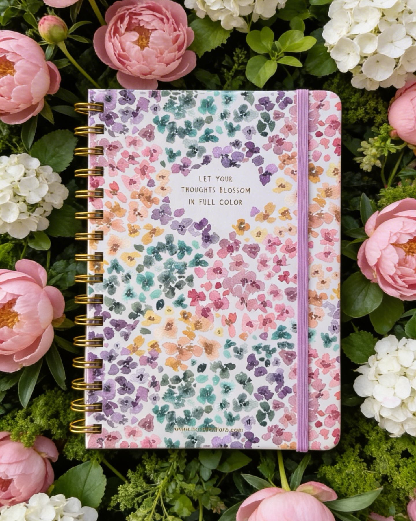 Floral notebook surrounded by pink and white flowers