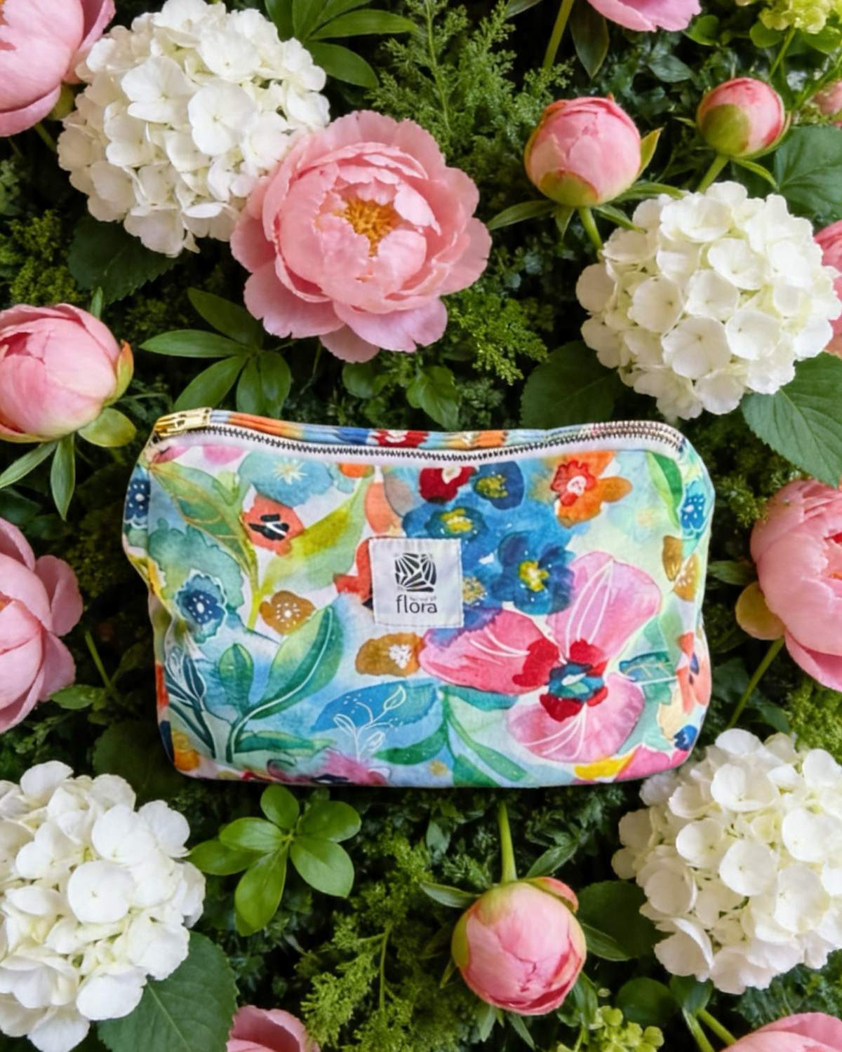 Colorful floral-patterned pouch on a bed of pink and white flowers